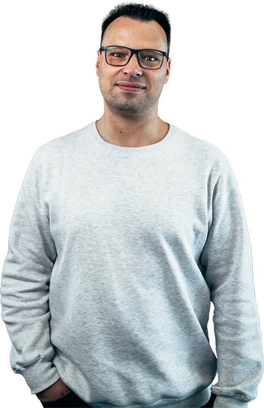 René Schneider steht lässig und lächelt